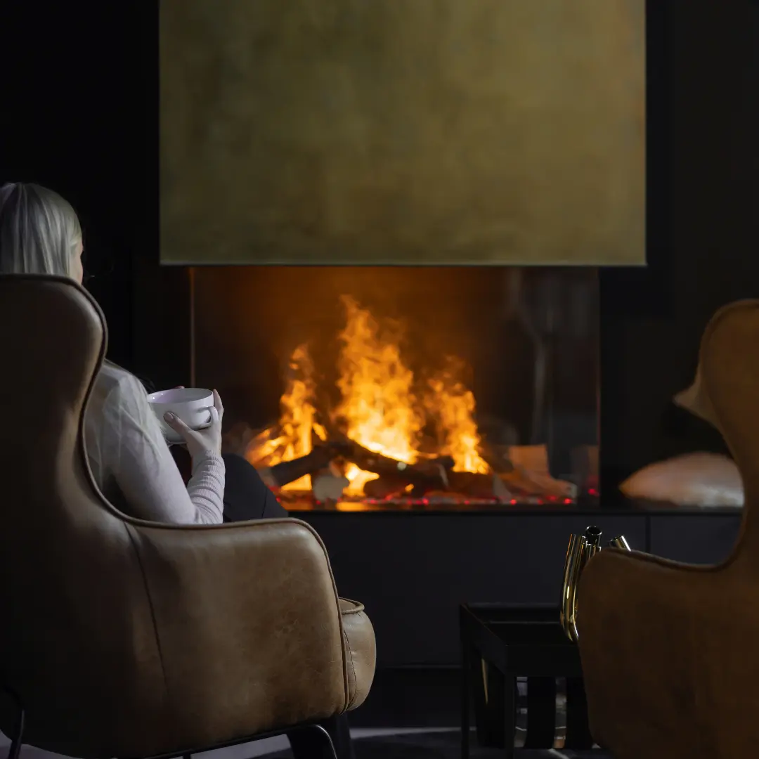 Glutart-Freifeuer-Elektrokamin-1 Elektrische Öfen für Hotels: Blick durch ein elektrisches Kaminfeuer in die Lounge Area eines Luxushotels